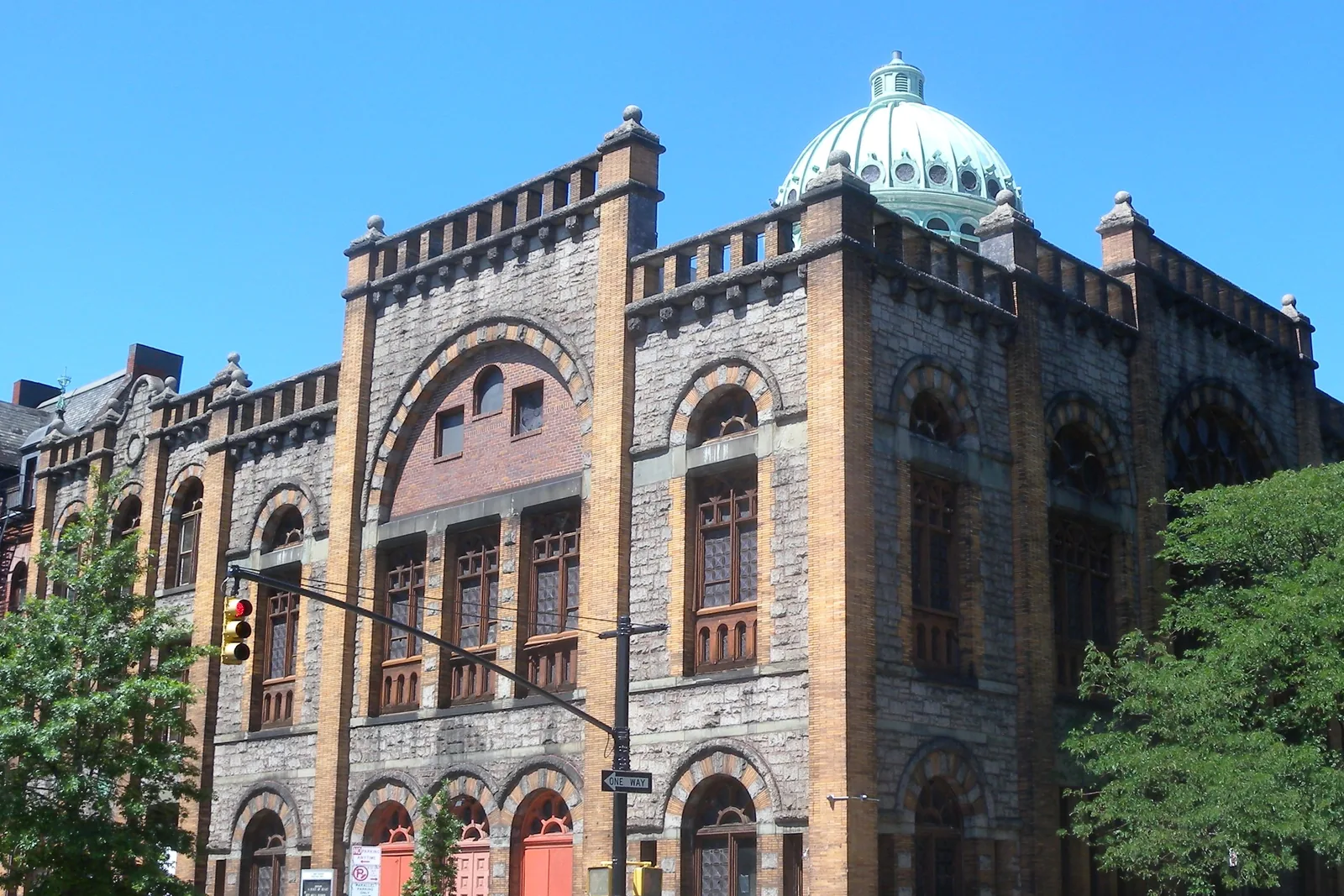 Harlem, kostel Mount Morris Ascension Presbyterian Church, žulová a zlato-cihlová budova s patinovanou zelenou měděnou kupolí, pohled z protější strany ulice za slunečného dne