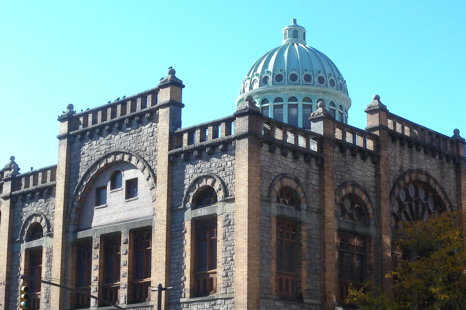 La cupola in rame verde e le pareti in mattoni dorati della Mount Morris Ascension Presbyterian Church ad Harlem sotto un cielo azzurro limpido